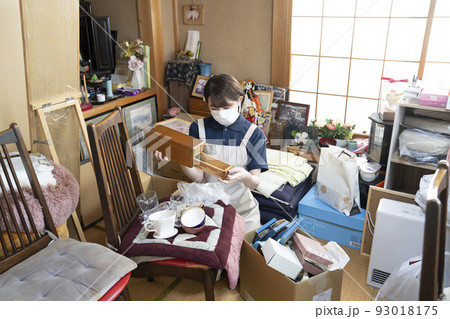 散らかった部屋の片付けをする女性作業員 散らかった部屋の片付けをする女性作業員 93018175