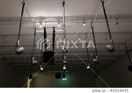 Young man listening to sound music surround installation with many speakers above Young man listening to sound music surround installation with many speakers above 93019435