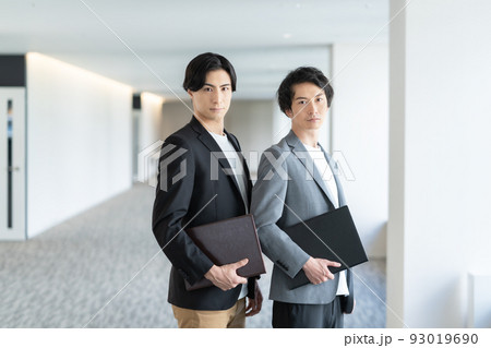 ファイルを持って立つ若いオフィスカジュアルなビジネスマン 撮影協力「LINK FOREST] 93019690