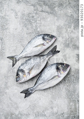 Whole dorado Sea bream fish with herbs for grill over textured grey background top view space for text. Whole dorado Sea bream fish with herbs for grill over textured grey background top view space for text. 93020173