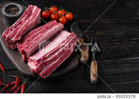 Fresh  premium wagyu beef rib, on black wooden table background, with copy space for text 93020578