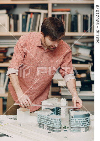 Architect with blueprints and layout buildings house design project at Bureau of Architecture. Architect with blueprints and layout buildings house design project at Bureau of Architecture. 93021079