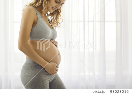 Happy pregnant woman caress big belly 93023016