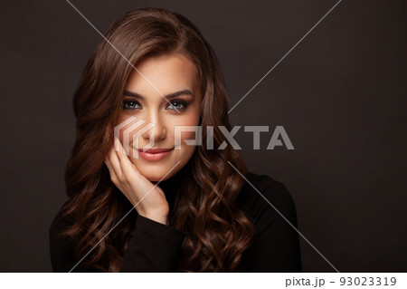 Brunette woman looking at camera and smiling on black background 93023319