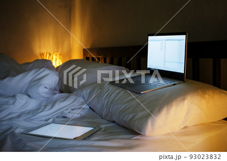 The laptop in the white bedroom. Lamps lightning softly. The laptop in the white bedroom. Lamps lightning softly. 93023832