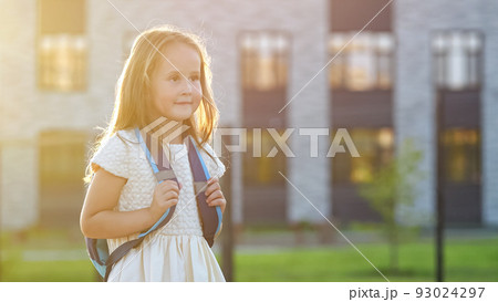 Happy girl goes to school smiling at back sunset light 93024297