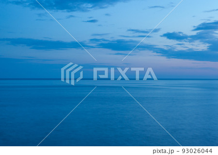Background from the blue sea and the blue-blue sky with clouds and horizont line in the middle. Blue seascape for publication, poster, screensaver, wallpaper, postcard, banner, cover, post. High 93026044