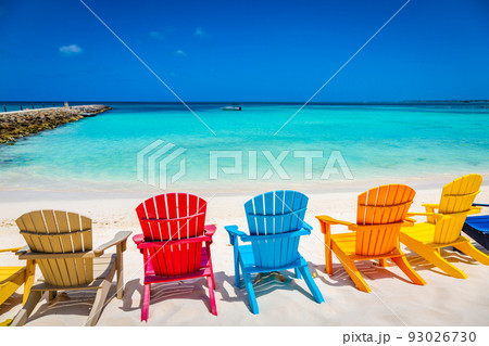 Idyllic beach with rustic adirondack chairs in Aruba, Dutch Antilles 93026730
