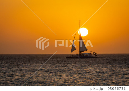 Idyllic beach with sailboat in Aruba at golden sunset, Dutch Antilles Idyllic beach with sailboat in Aruba at golden sunset, Dutch Antilles 93026731