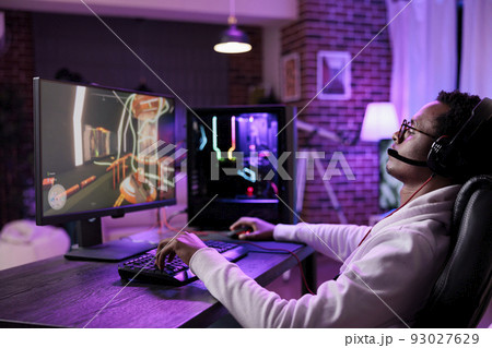 Internet vlogger broadcasting live video games play on computer, having fun with online game championship tournament on stream. Virtual gamer playing esport competition at desk with neon lights. 93027629