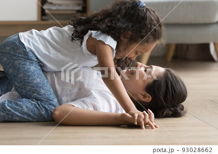 Happy little Indian kid girl resting on laughing mom Happy little Indian kid girl resting on laughing mom 93028662