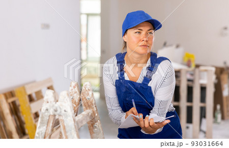 Portrait of a woman engineer making notes on paper 93031664