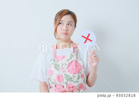 左手で×札を持つ不機嫌そうな女性 左手で×札を持つ不機嫌そうな女性 93032818