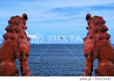 シーサーと沖縄の海岸 93033481