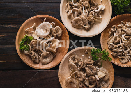 Fresh edible mushroom in natural plate on wooden background 93035188