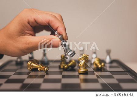 Hand man holding chess game stand on chessboard.Business strategy teamwork success investment concept. Hand man holding chess game stand on chessboard.Business strategy teamwork success investment concept. 93036342