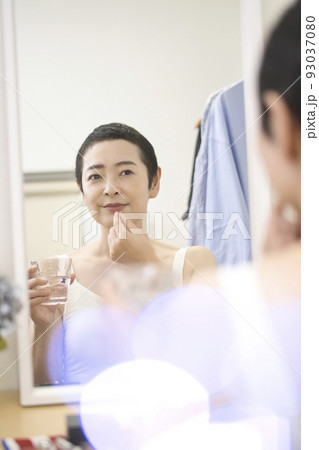 ビューティ 鏡の前で薬を飲むショートヘアのミドル女性 ビューティ 鏡の前で薬を飲むショートヘアのミドル女性 93037080