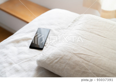 ベッドに置かれたスマホ ベッドに置かれたスマホ 93037391