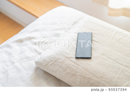 ベッドに置かれたスマホ ベッドに置かれたスマホ 93037394