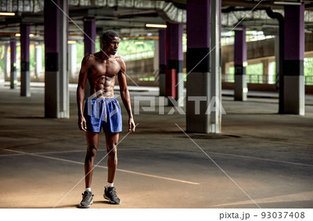Handsome afro American sportman standing on the street while taking break after training. Black male having rest after workout Handsome afro American sportman standing on the street while taking break after training. Black male having rest after workout 93037408