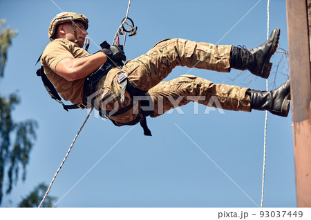 Special forces fighter descends from a skyscraper to storm the apartment. SWAT, police, counter terrorism concept. Mixed media Special forces fighter descends from a skyscraper to storm the apartment. SWAT, police, counter terrorism concept. Mixed media 93037449