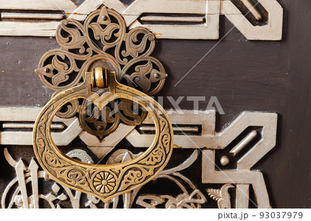 Vintage handle on an old oriental wooden door Vintage handle on an old oriental wooden door 93037979