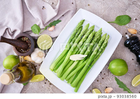 Green organic natural Asparagus in ceramic white plate on kitchen table Green organic natural Asparagus in ceramic white plate on kitchen table 93038560