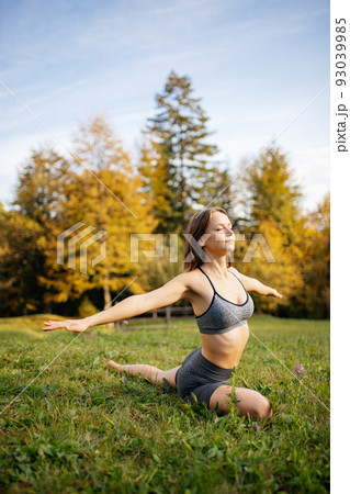 Young woman in sportswear practicing yoga and meditation doing breathing exercises outdoors. Young woman in sportswear practicing yoga and meditation doing breathing exercises outdoors. 93039985