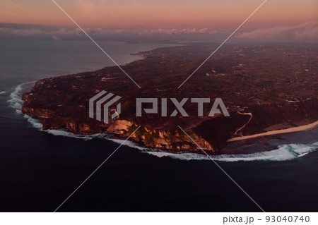 Aerial view of peninsula with cliff and ocean with warm sunset in Bali Aerial view of peninsula with cliff and ocean with warm sunset in Bali 93040740