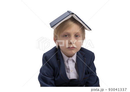 Tired schoolboy is isolated on white background. Portrait of boy in jacket or school uniform with book on his head. Tired schoolboy is isolated on white background. Portrait of boy in jacket or school uniform with book on his head. 93041337