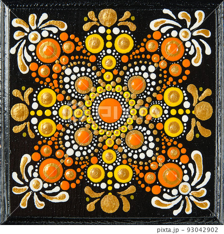 Mandala dot art painting on wood tiles. Beautiful mandala hand painted by colorful dots on black wood. National patterns with acrylic paints, handwork, dot painting. Abstract dotted background. 93042902