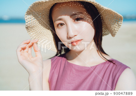 海辺で遊ぶ麦わら帽子の女性 海辺で遊ぶ麦わら帽子の女性 93047889