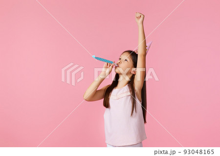 happy little birthday girl with party cone hat and whistle 93048165