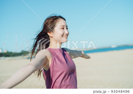 青空の下海辺で遊ぶワンピース若い女性 93048496