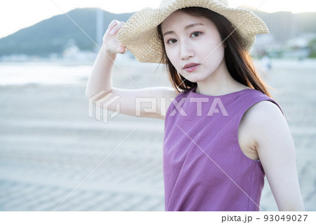 海辺で遊ぶ麦わら帽子の若い女性 海辺で遊ぶ麦わら帽子の若い女性 93049027