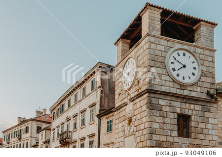 The clock tower on the army square at the entrance gate in the medieval city of Kotor. Evening view. Kotor, Montenegro 93049106