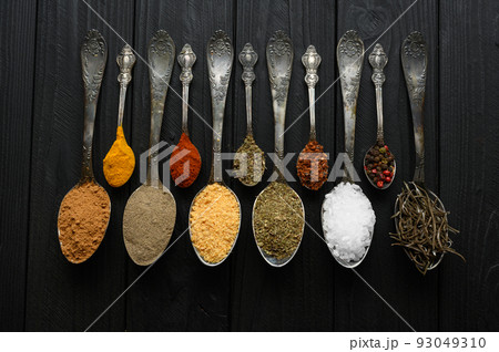 Colorful various herbs and spices for cooking on dark wooden rustic background Colorful various herbs and spices for cooking on dark wooden rustic background 93049310