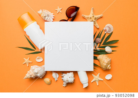 Summer time concept with blank greeting card and blank white paper on colored background. Seashells from ocean shore in the shape of frame separated with space for text top view Summer time concept with blank greeting card and blank white paper on colored background. Seashells from ocean shore in the shape of frame separated with space for text top view 93052098