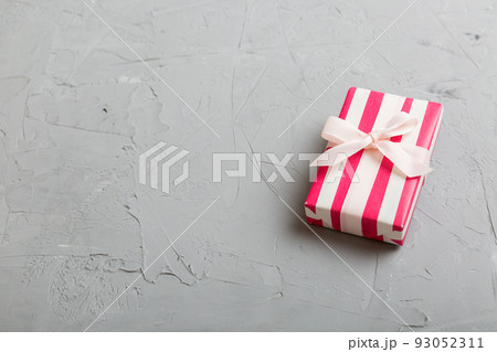 wrapped Christmas or other holiday handmade gift box in color paper with ribbon on colored background. Present box, decoration of gift on colored table, top view with copy space wrapped Christmas or other holiday handmade gift box in color paper with ribbon on colored background. Present box, decoration of gift on colored table, top view with copy space 93052311