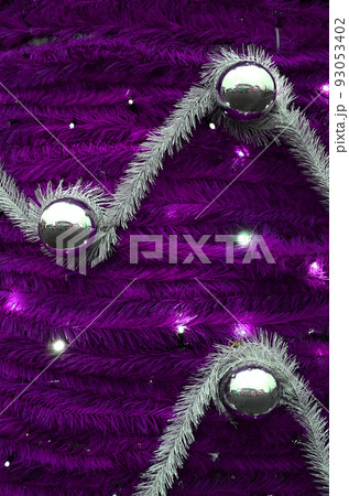 Texture of the wall decorated with New Year's fluffy ribbons and decorations in the form of glossy balls Texture of the wall decorated with New Year's fluffy ribbons and decorations in the form of glossy balls 93053402