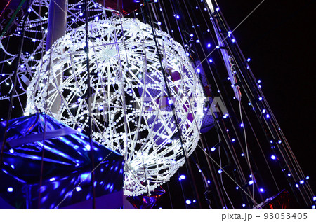Fragment of the New Year tree. A lot of round lights of blue color are located on a conical frame 93053405