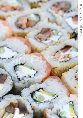 Close-up of a lot of sushi rolls with different fillings. Macro shot of cooked classic Japanese food. Background image 93053916