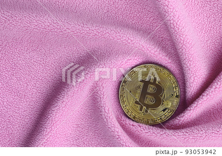 The golden bitcoin lies on a blanket made of soft and fluffy light pink fleece fabric with a large number of relief folds. The shape of the folds resembles a fan from a video card cooler 93053942