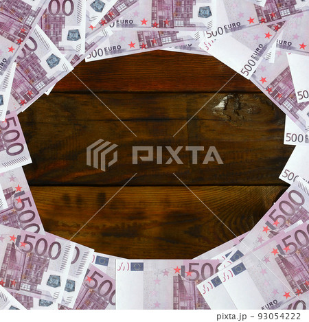 A lot of purple denominations worth 500 euros lie on a wooden surface with an empty pad in the middle of the image. Copy space for text A lot of purple denominations worth 500 euros lie on a wooden surface with an empty pad in the middle of the image. Copy space for text 93054222