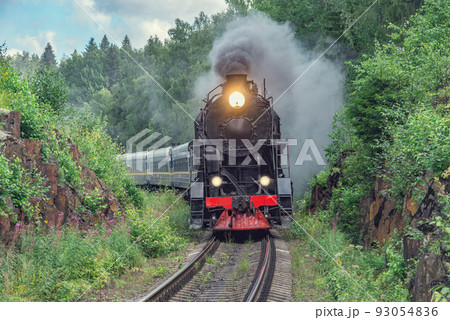 Retro steam train approaches to the platform. 93054836