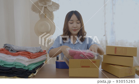 Business concept of 4k Resolution. Asian woman packing products in boxes at home. Business concept of 4k Resolution. Asian woman packing products in boxes at home. 93055265