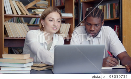 4K. Students study together in the library. Students prepare for exams, write notes. 4K. Students study together in the library. Students prepare for exams, write notes. 93059735