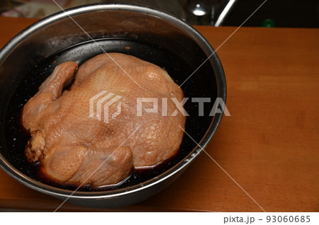 クリスマスパーティー用に一羽の鶏をオーブンで焼く前に付けダレで味付け クリスマスパーティー用に一羽の鶏をオーブンで焼く前に付けダレで味付け 93060685