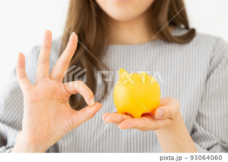 豚の貯金箱を持つ若い女性 豚の貯金箱を持つ若い女性 93064060