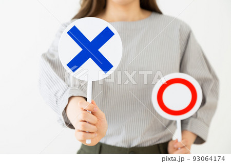 丸ばつプレートを持つ若い女性 93064174